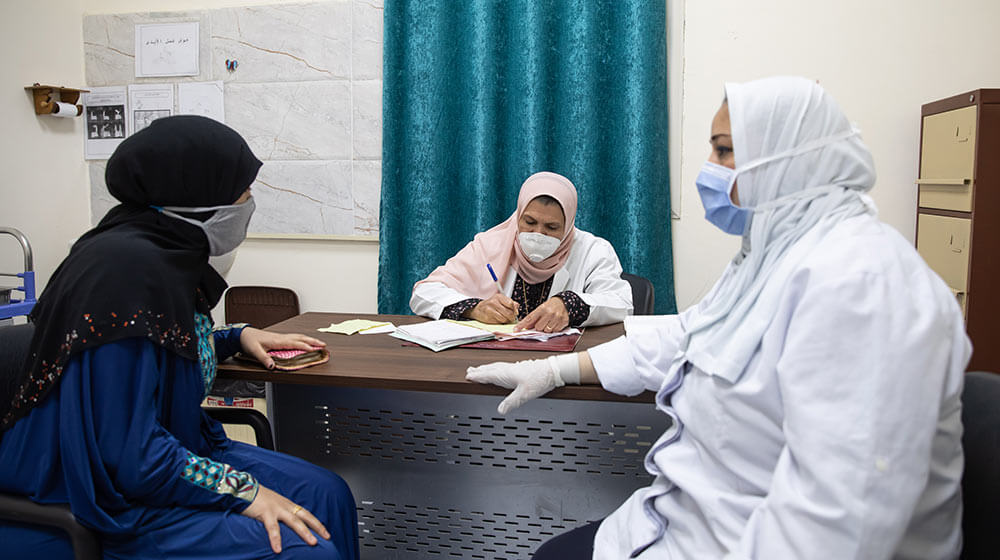 Masked woman receives a family planning consultation in Egypt.