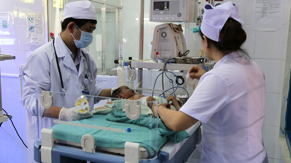 Health care workers care for a newborn in Veitnam.