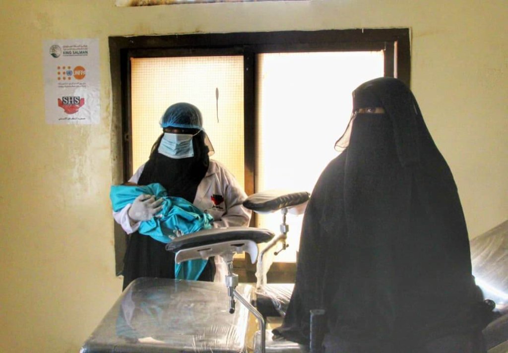 A midwife holds the baby of woman who has just given birth in Yemen. UNFPA  is working to provide humanitarian aid to the country in 2021. Over 1.2 million pregnant Yemeni women are acutely malnourished.