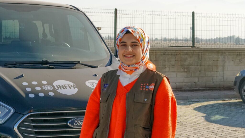 Azize in front of the WGSS transportation van. © UNFPA Türkiye/Eren Korkmaz