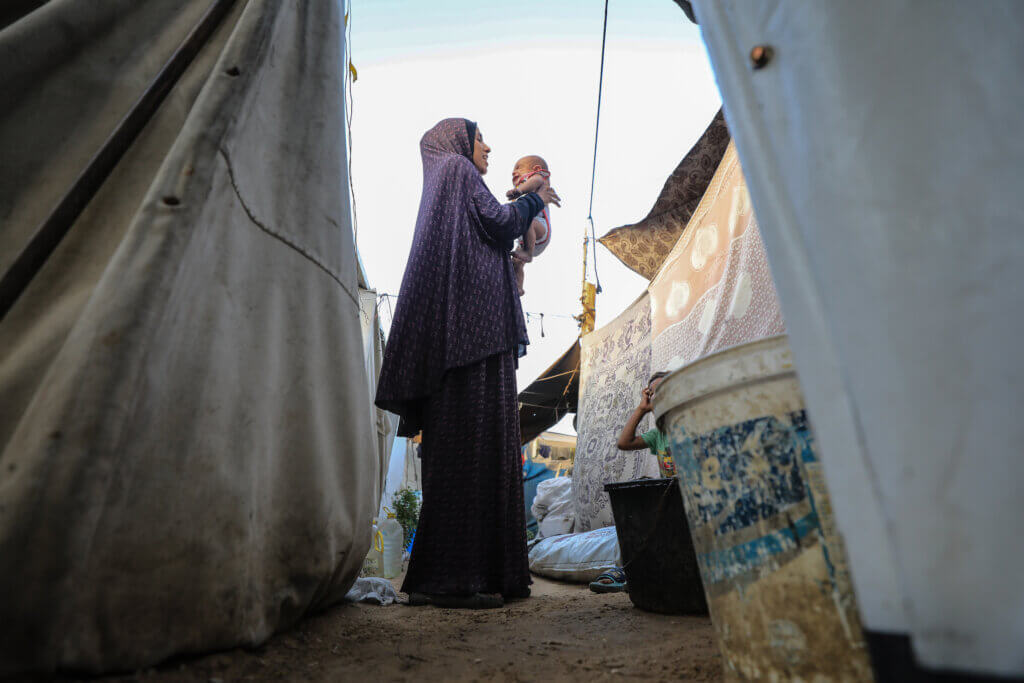 Mother holds her baby at a displacement camp.