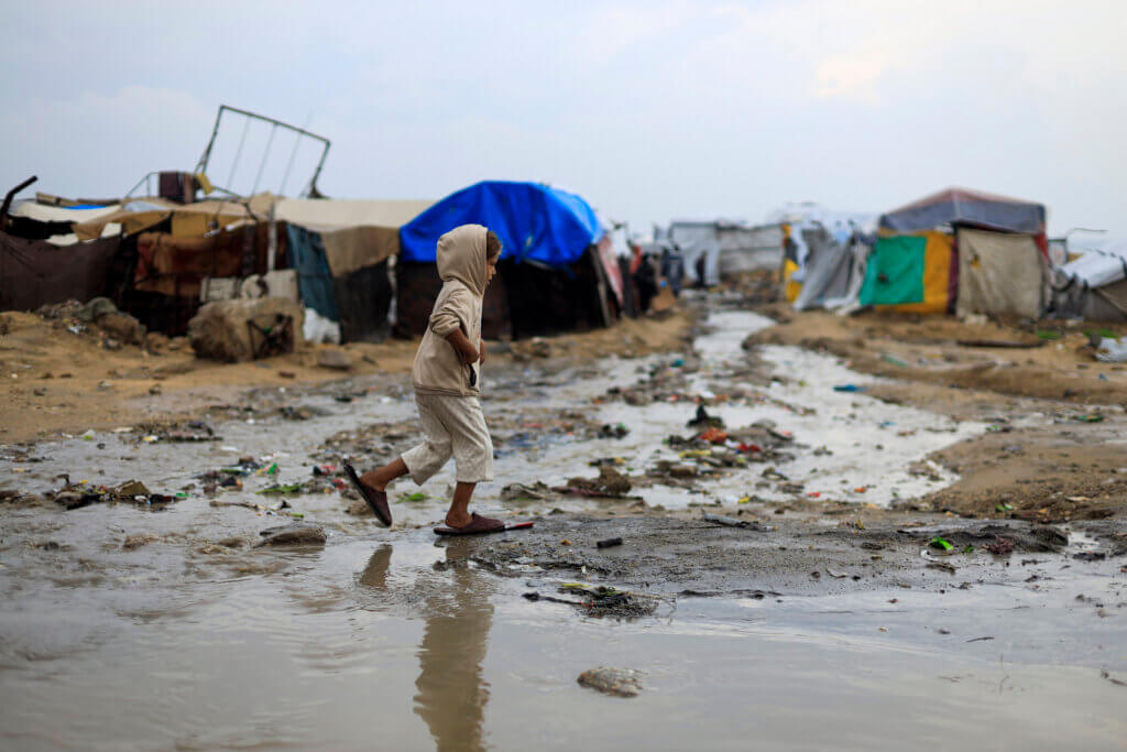A child walks through flooded streets of Gaza. The cold is worsening the crisis.